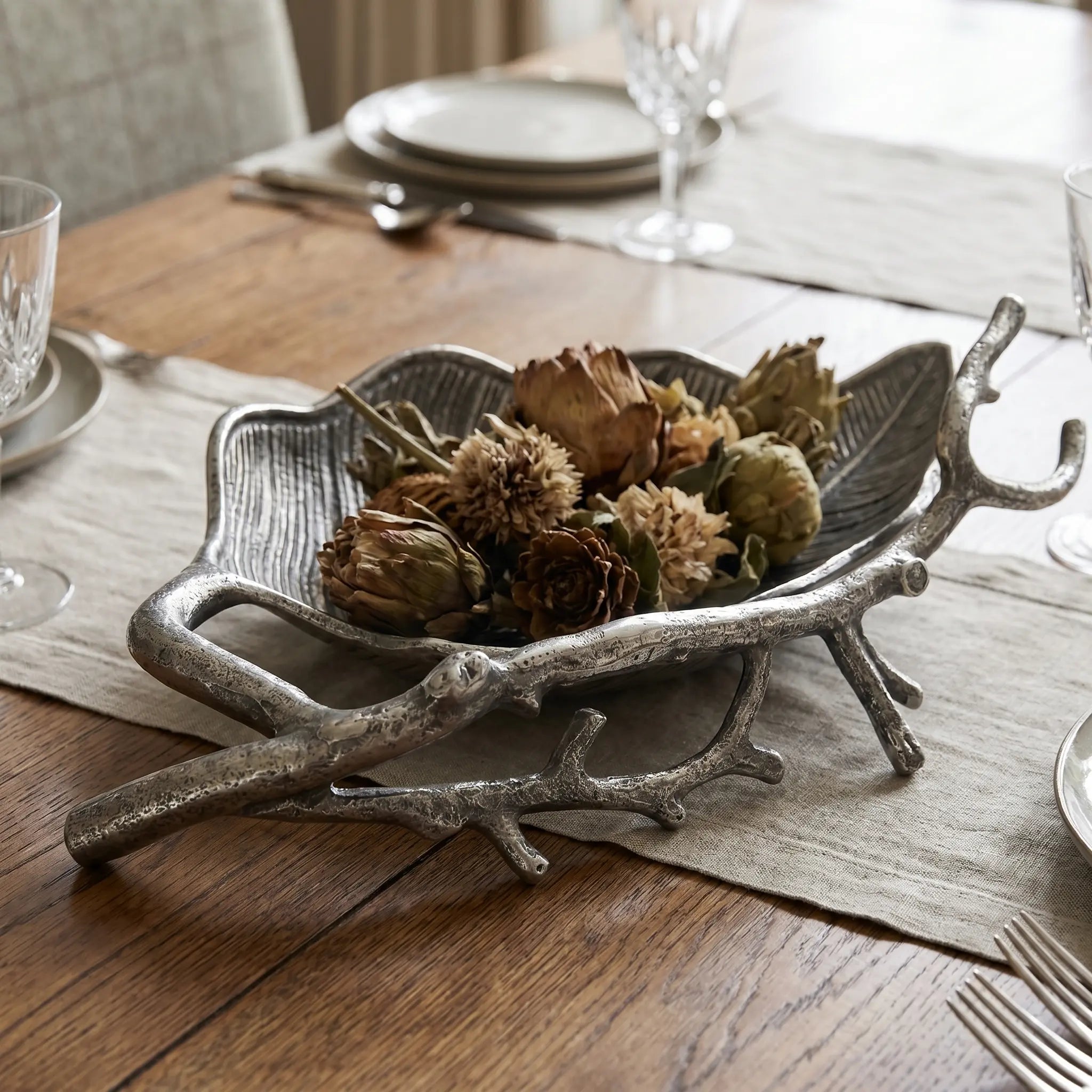 Woodland Metal Bowl in aluminium with leaf-inspired texture, filled with pinecones on a rustic tray.