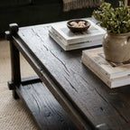 Millhouse Coffee Table in solid fir with walnut stain, low profile and open lower shelf, with books and vase.