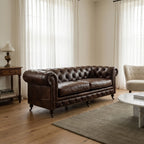 Ashcroft Sofa, three-seat, top-grain South American leather, deep buttoned Chesterfield, brass studs, rolled arms.