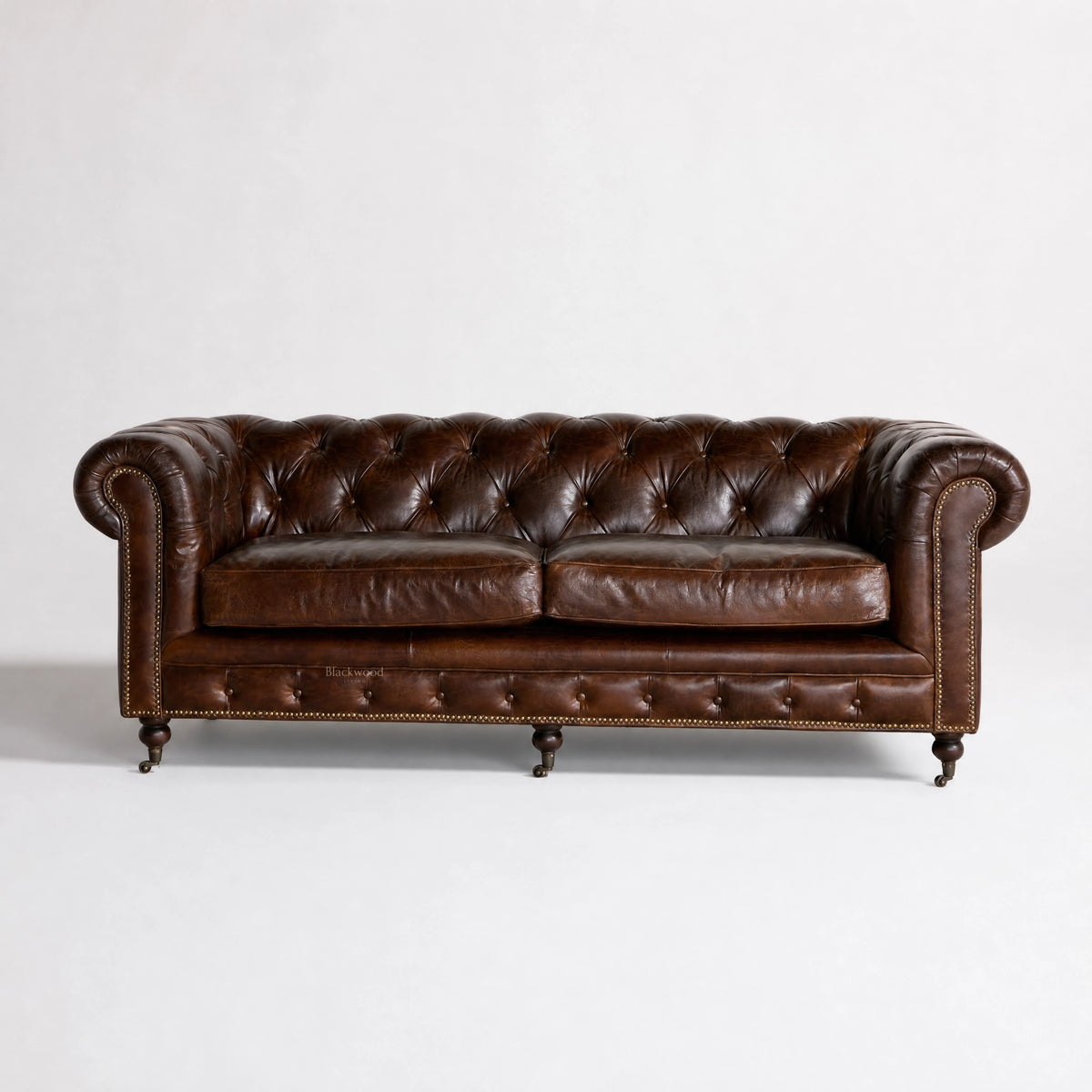 Ashcroft Sofa Three Seat in South American top-grain leather with deep buttoned Chesterfield brass studs, rolled arms.