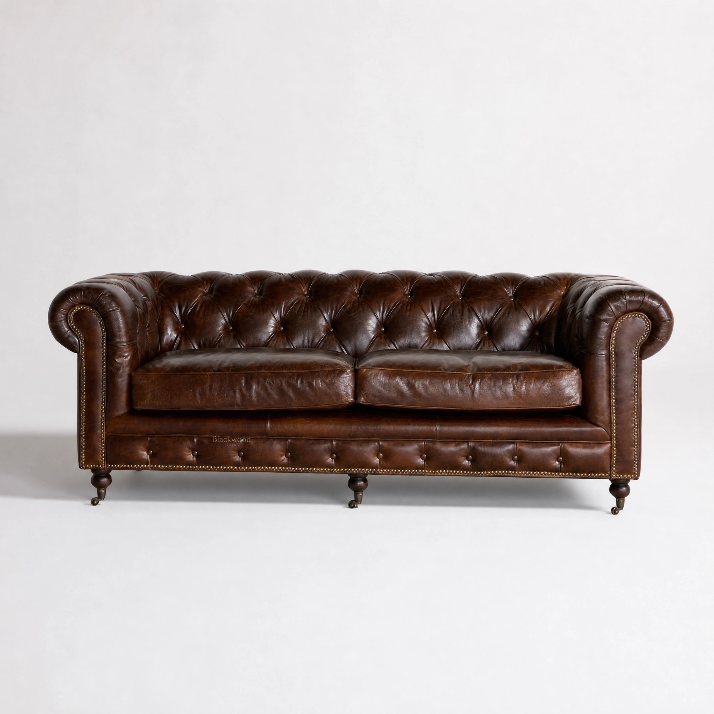 Ashcroft Sofa Three Seat in South American top-grain leather with deep buttoned Chesterfield brass studs, rolled arms.