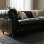 Ashcroft Sofa, three-seat, black top-grain leather, deep buttoned Chesterfield with brass studs and rolled arms.