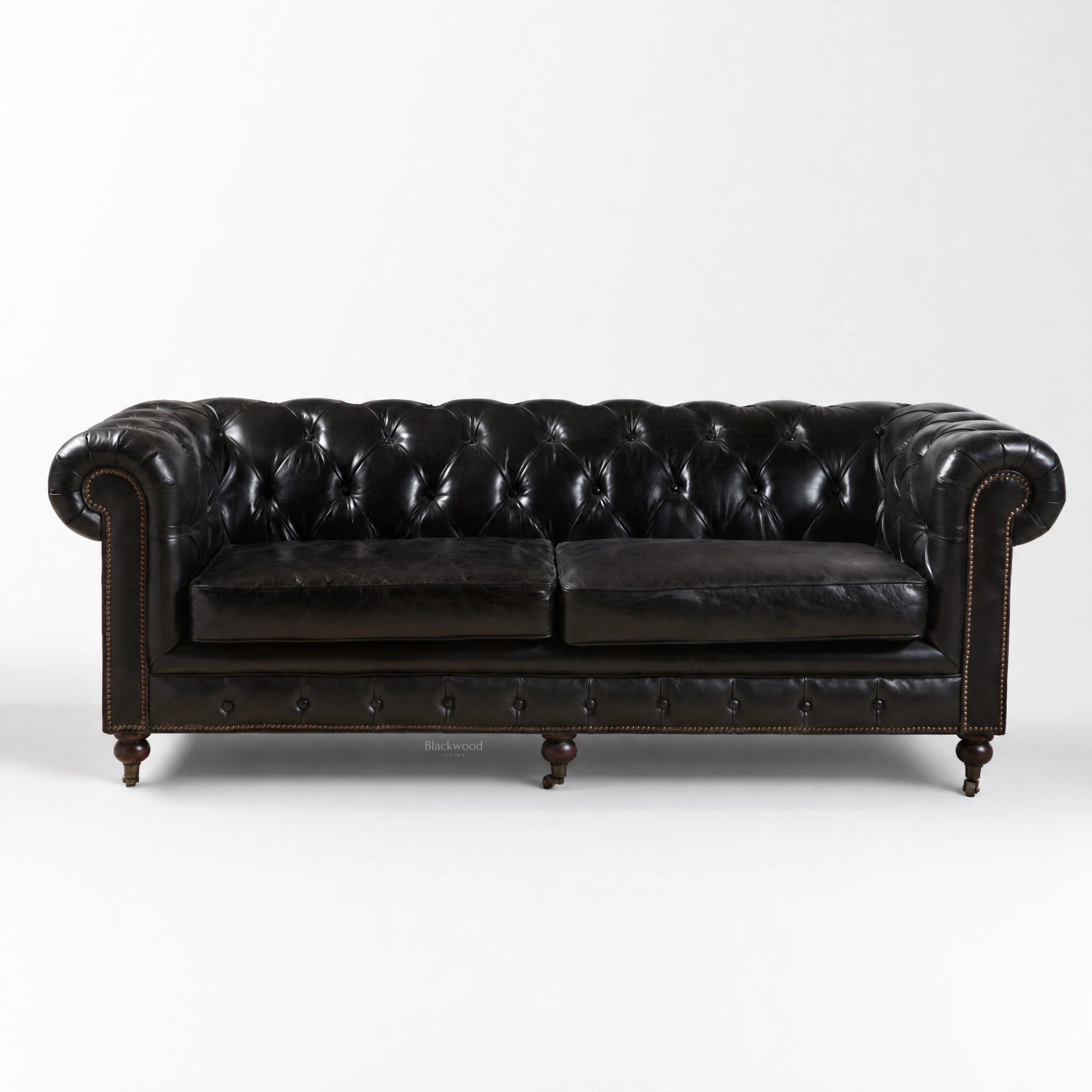 Ashcroft Sofa - Three Seat in black topgrain cow leather, deep buttoned Chesterfield, rolled arms, brass studs.