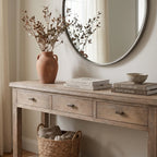 Wetherby Hall Table in weathered solid poplar with framed drawers and lower shelf, with vase, books, and round mirror.