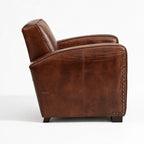 Kingsford Leather Armchair in Vintage Tobacco leather with deep seat and metal studs along edge.
