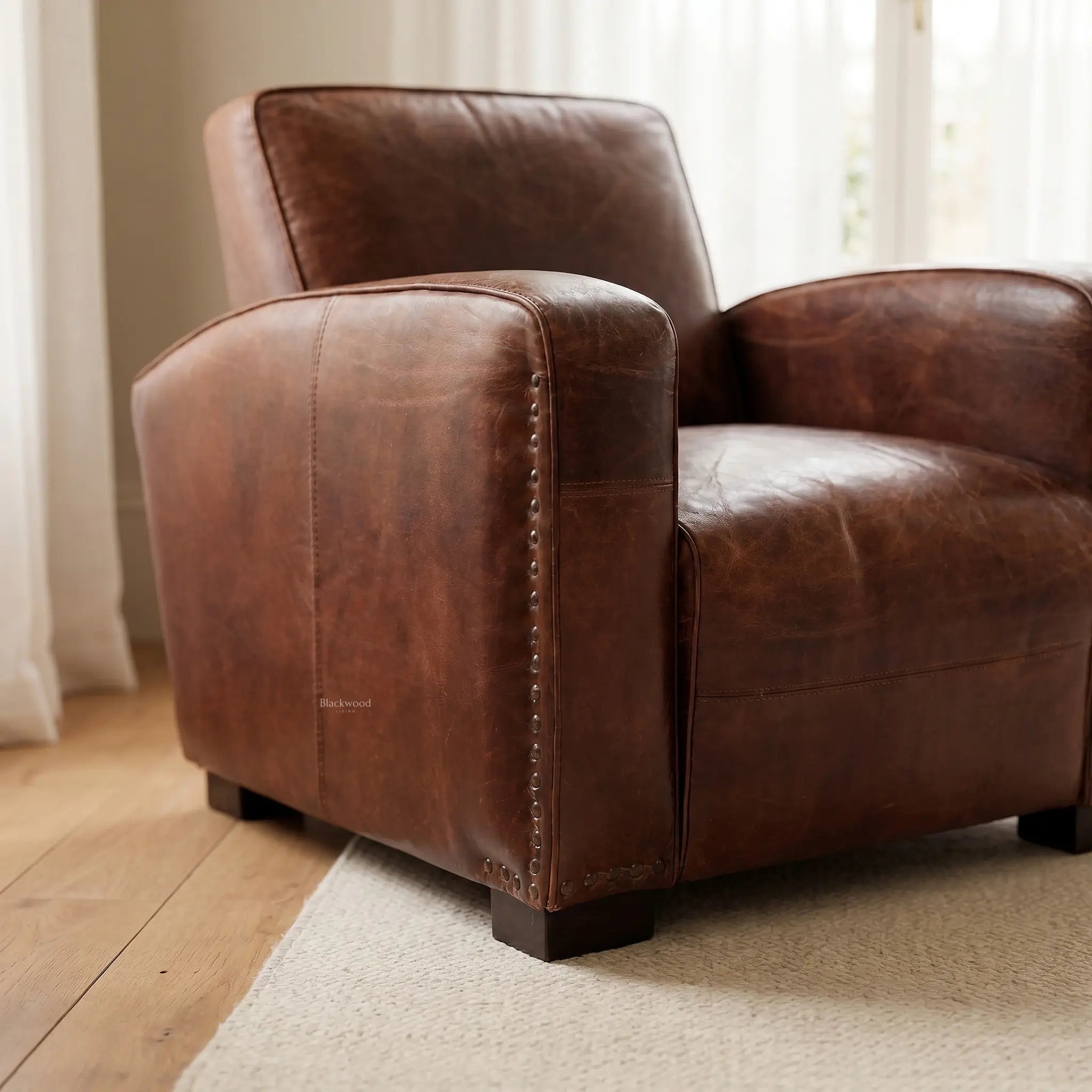 Kingsford Leather Armchair in Vintage Tobacco leather, close-up of studded arm and deep seat.
