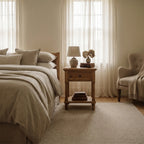 Oakridge Bedside Table in a cozy bedroom, solid oak with framed drawer fronts, turned legs, and a lower shelf.
