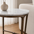 Montclair Marble Side Table with round white marble top and sculptural iron base, beige vase on top.