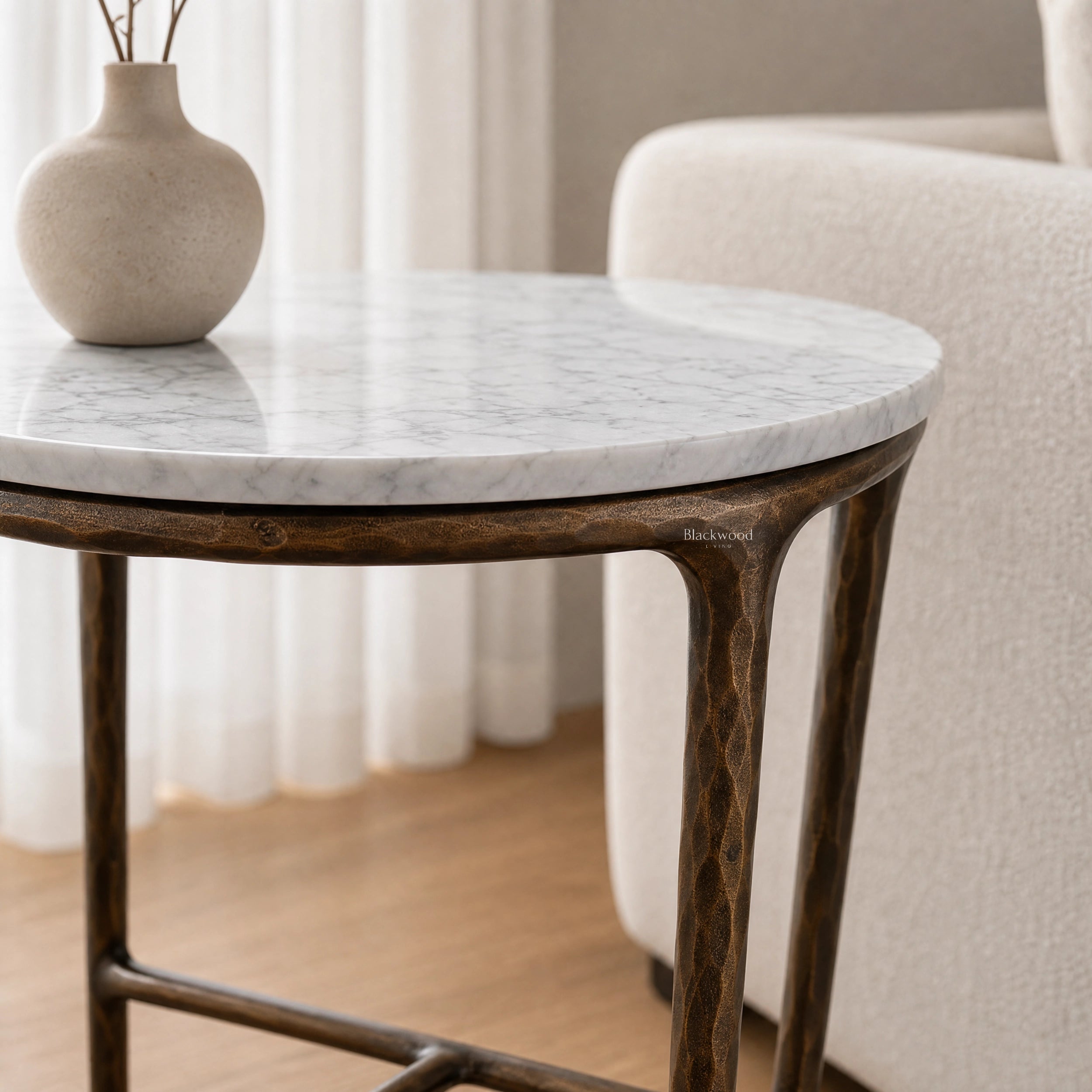 Montclair Marble Side Table with round white marble top and sculptural iron base, beige vase on top.