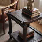 Millhouse Side Table in solid fir with exposed joinery, dark finish, beside stacked books and a stone sculpture