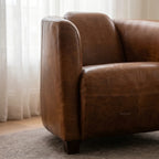 Dalton Club Chair arm in brown South American top grain cow leather on a solid rubber wood frame.
