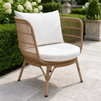 Clifton Outdoor 3-Piece Setting chair with white cushion in a garden, handwoven wicker over aluminum frame.