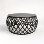 Mara Coffee Table: round iron top and plantation-inspired lattice metal base.