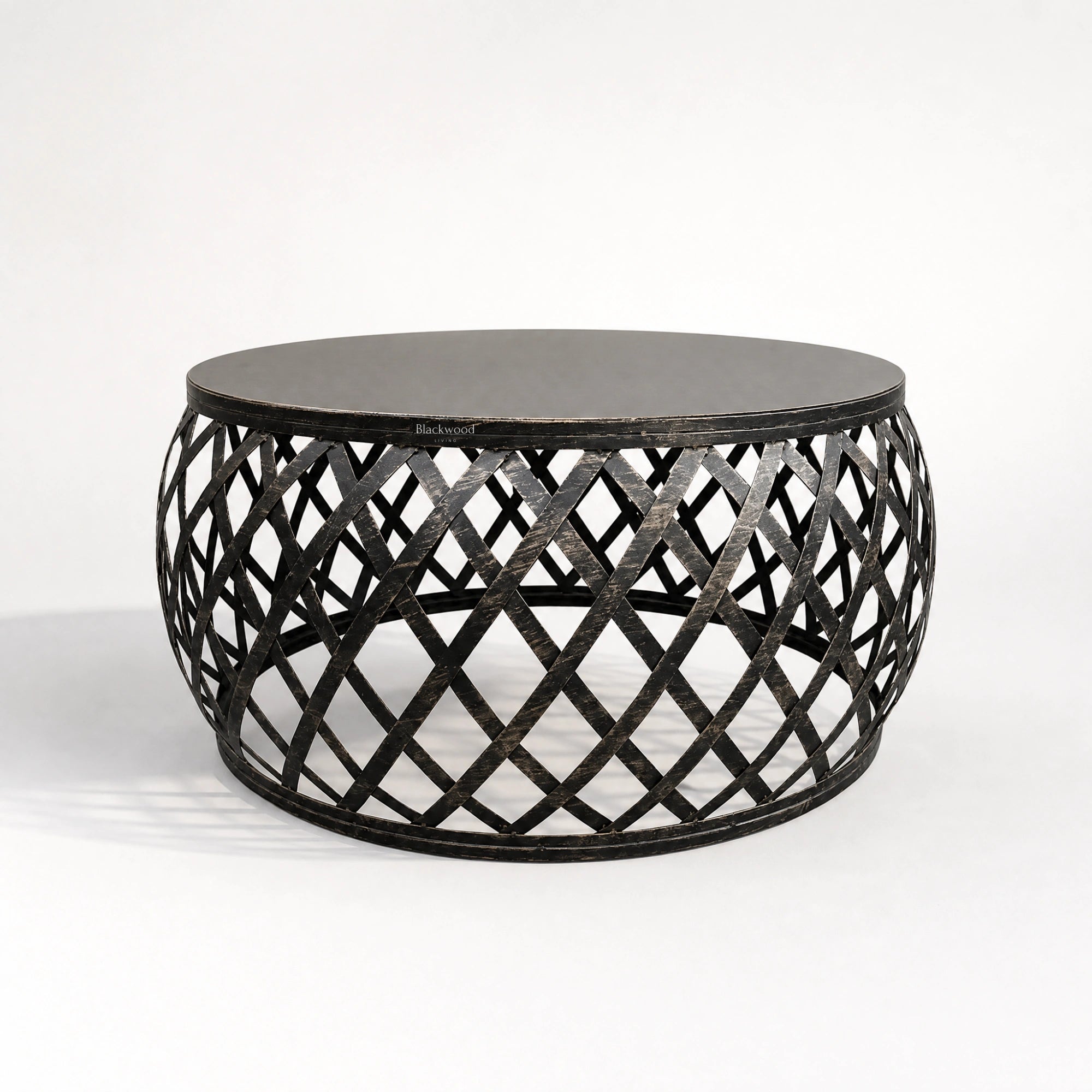 Mara Coffee Table: round iron top and plantation-inspired lattice metal base.