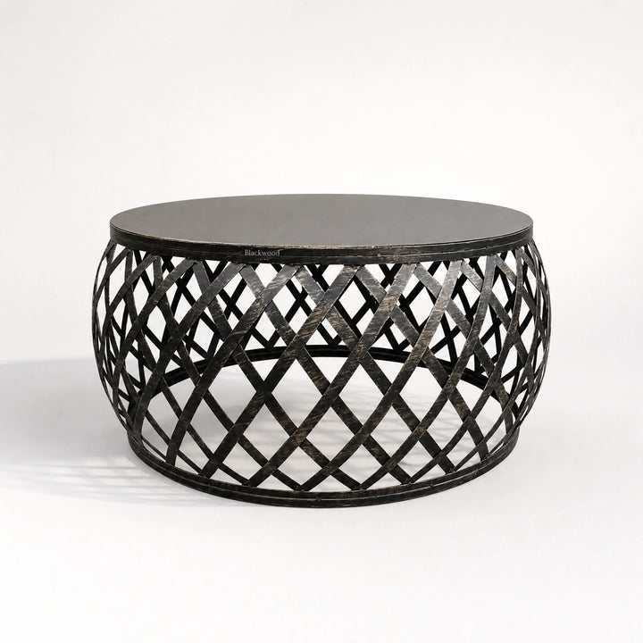 Mara Coffee Table: round iron top and plantation-inspired lattice metal base.