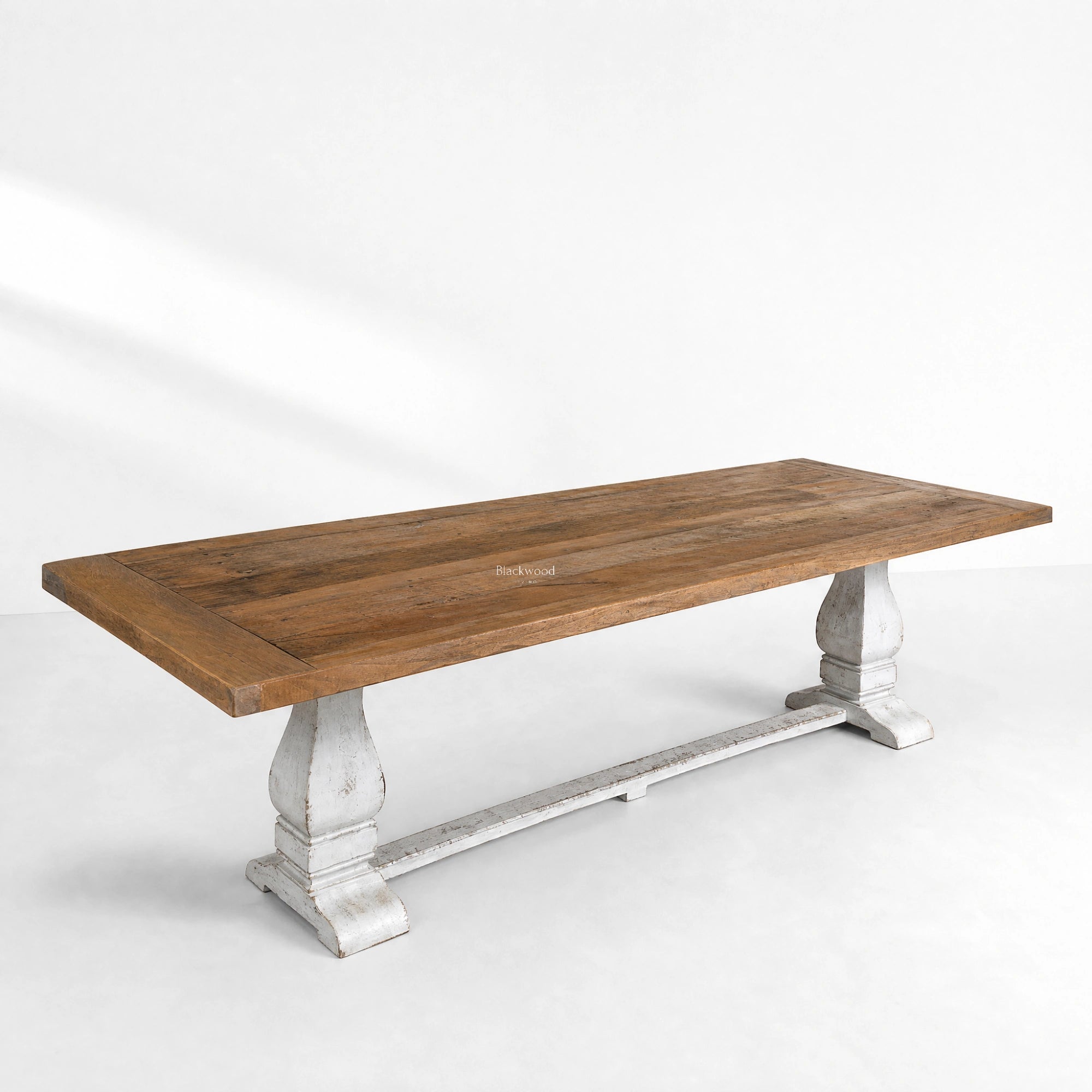 Eastport Dining Table crafted from reclaimed boat wood with teak tones and rustic white trestles.
