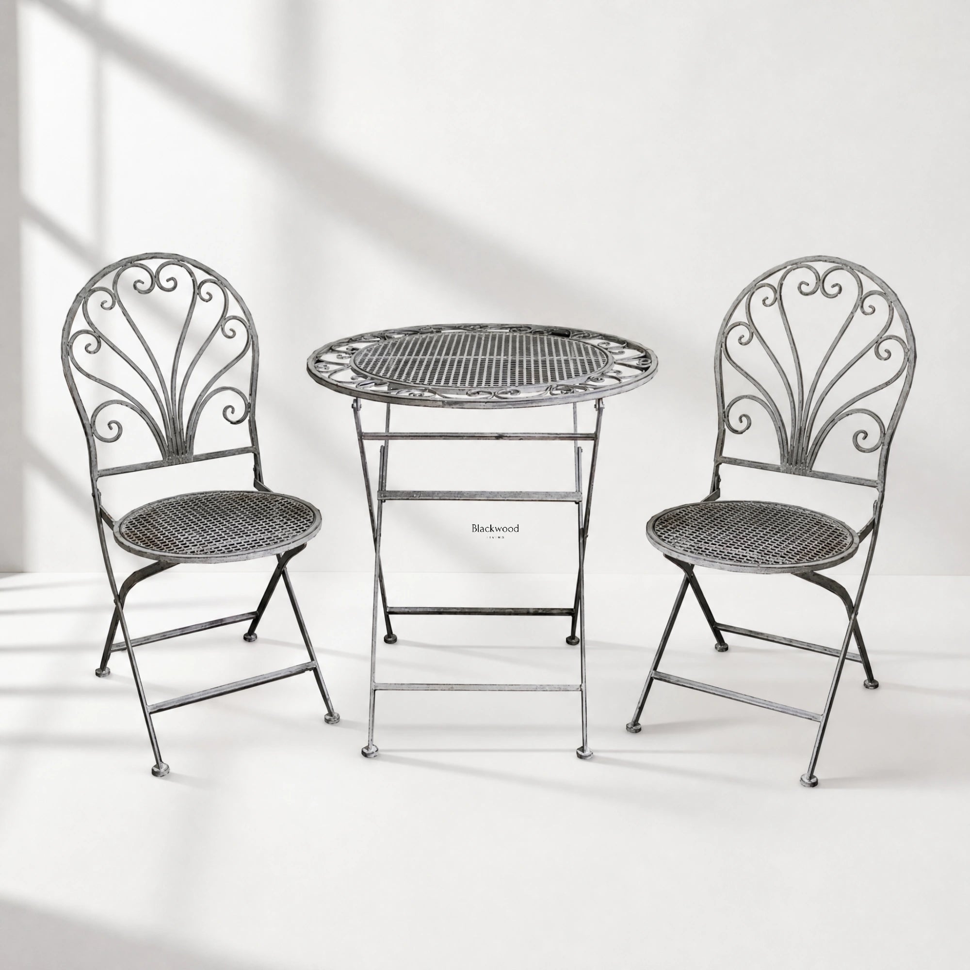 Provence Bistro Set in weathered antique grey with ornate scrollwork chairs and round mesh table.