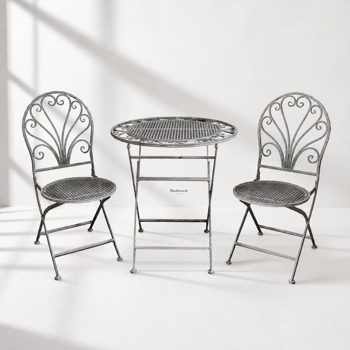 Provence Bistro Set in weathered antique grey with ornate scrollwork chairs and round mesh table.