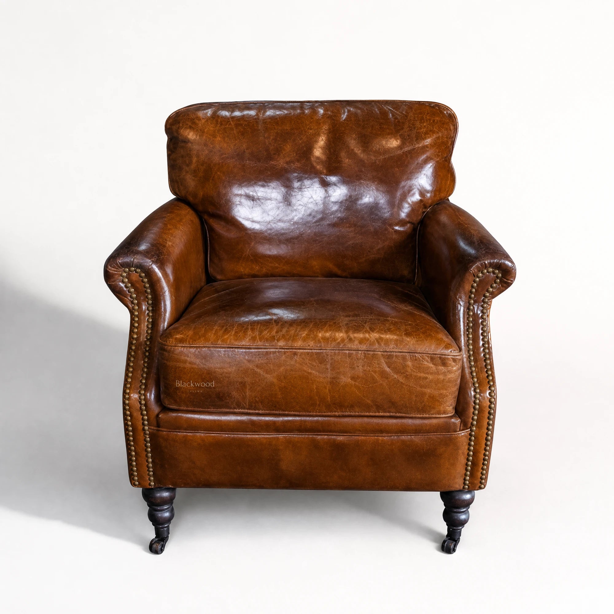Kensington Leather Club Chair in vintage tobacco leather with nailhead trim and dark wooden legs