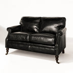 Belgravia 2-seat Estate Black leather sofa with nailhead trim and wooden turned legs.