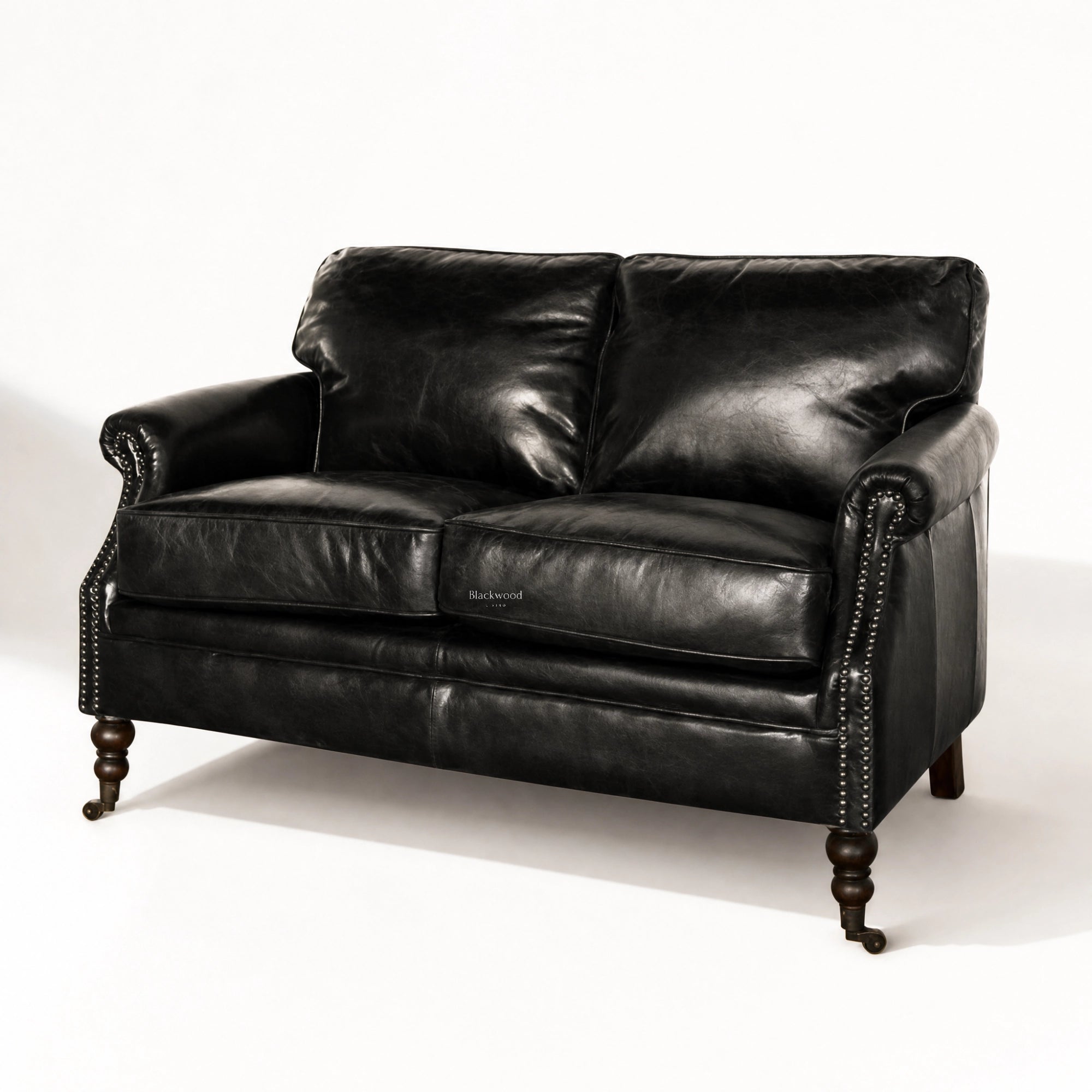 Belgravia 2-seat Estate Black leather sofa with nailhead trim and wooden turned legs.