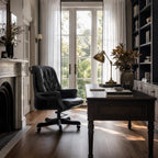 The Merchant Chair Estate Black in a refined home office with South American top-grain leather and a dark wood desk.