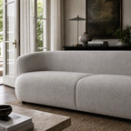 Amani Sofa with softly curved silhouette and textured upholstery in a calm, inviting living room setting.