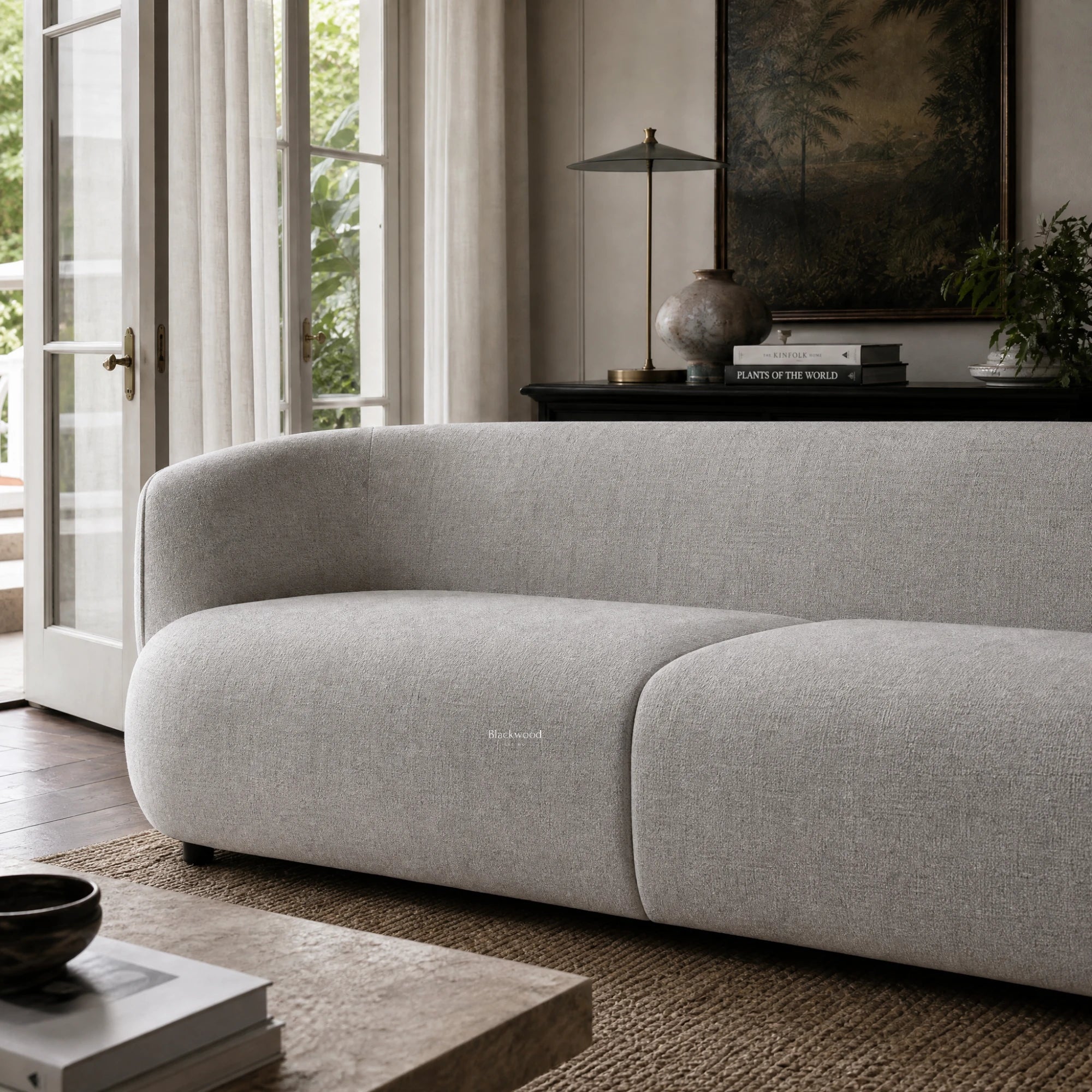 Amani Sofa with softly curved silhouette and textured upholstery in a calm, inviting living room setting.