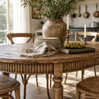 Loire Dining Table in reclaimed elm with weathered finish, round carved pedestal, greenery centerpiece.