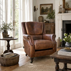 Beaumont Armchair in vintage tobacco leather, inviting, in a warm living room with fireplace and books.