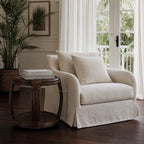 Havana Side Table with handwoven natural rattan and curved silhouette sits beside a cream sofa in a sunlit living room.