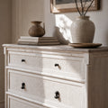 Laguna Dresser with light finish, woven cane drawers, paired with ceramics and books in a coastal vignette.