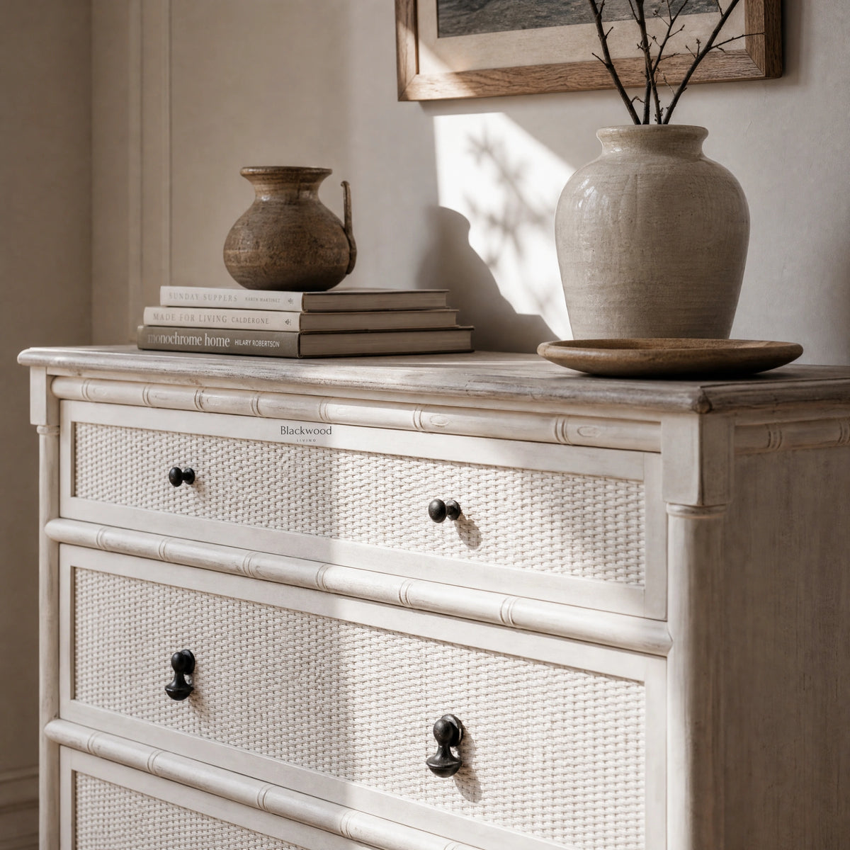 Laguna Dresser with light finish, woven cane drawers, paired with ceramics and books in a coastal vignette.