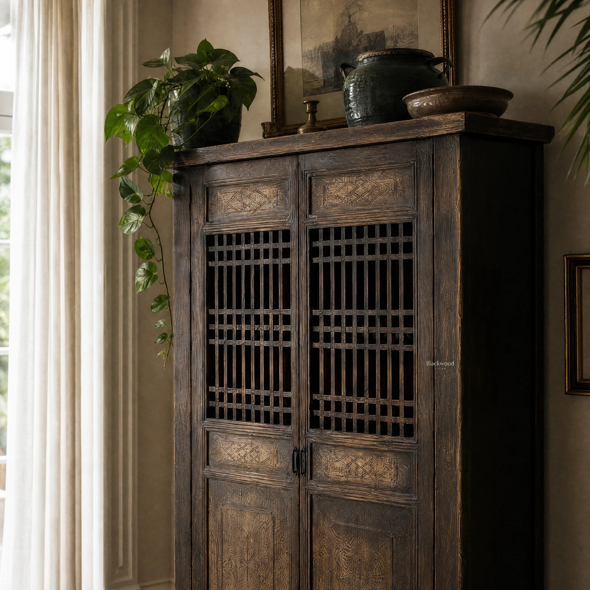 Shanghai Cabinet in weathered reclaimed pine with lattice doors and timeworn finish, topped by a plant and rustic pots.