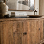 Portland Sideboard in reclaimed elm with weathered finish, paired with books, a large ceramic vase, and a lantern.