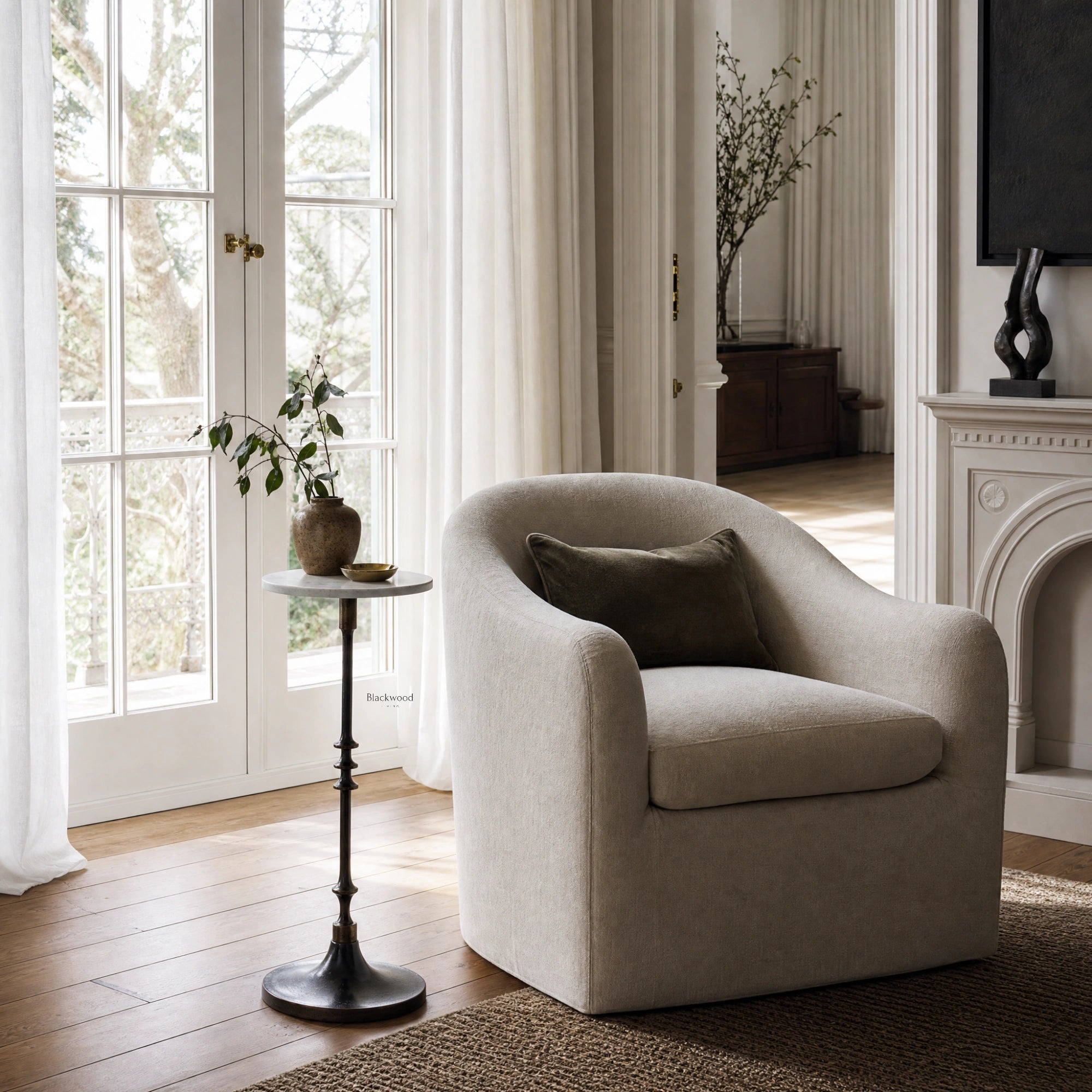 Mayfair Marble Side Table with white marble top and slender black iron pedestal in a bright living room.