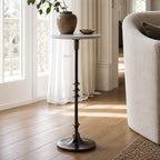 Mayfair Marble Side Table with white marble top and black iron pedestal beside a brass bowl and vase in a living room.