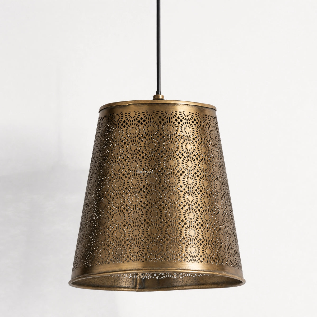 Ceylon Pendant in pierced antique brass with lantern-inspired perforations and warm, patterned glow.