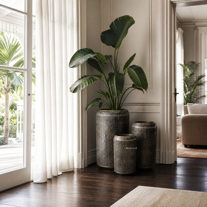 Sumatra Planters Set/3 in aged antique-brass aluminium with softly ribbed surfaces, shown indoors.