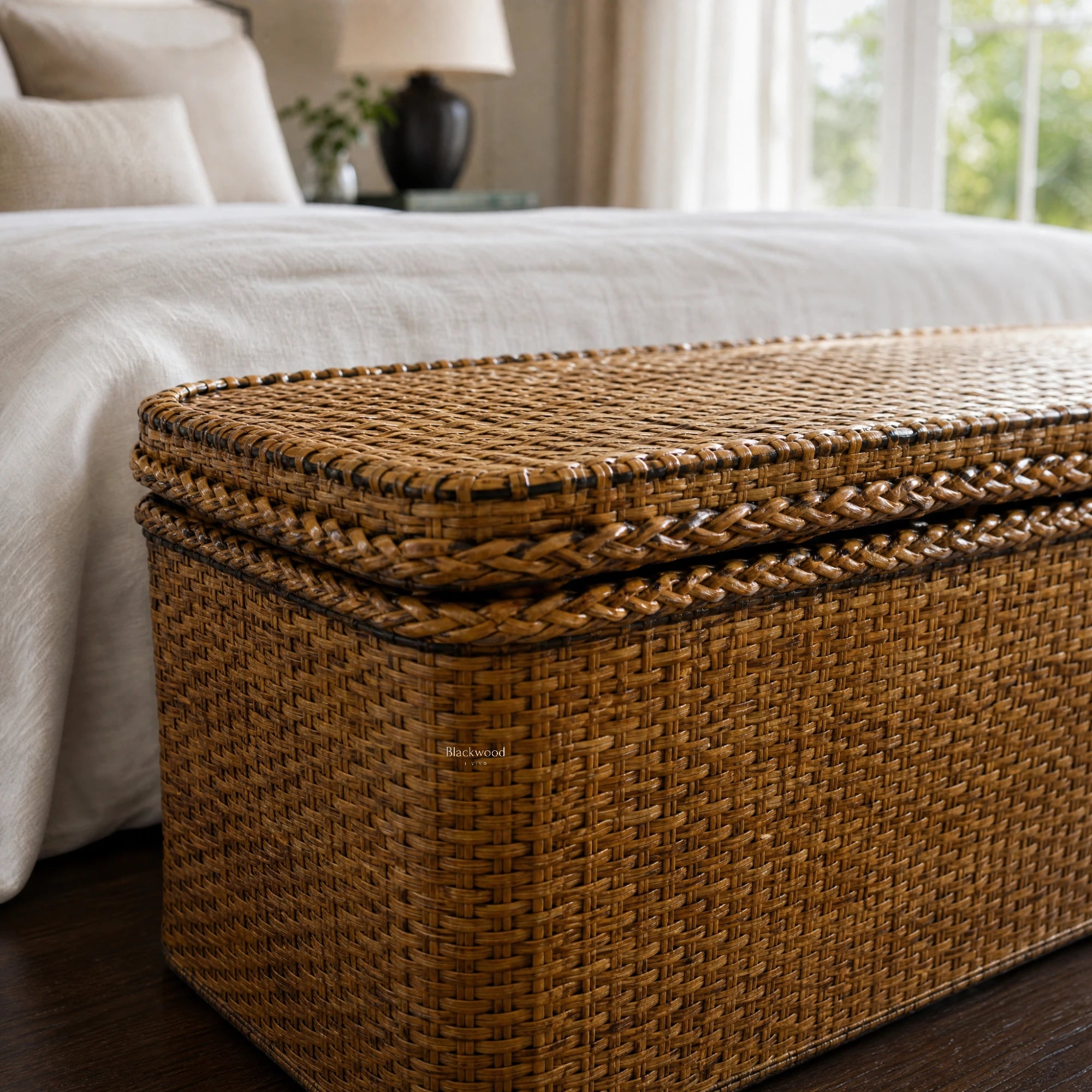 Tamarind Blanket Box crafted in natural woven rattan, stacked by a white bed for storage and plantation-style charm.