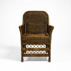 Malacca Accent Chair in woven natural rattan with curved arms and high back, warm plantation style.