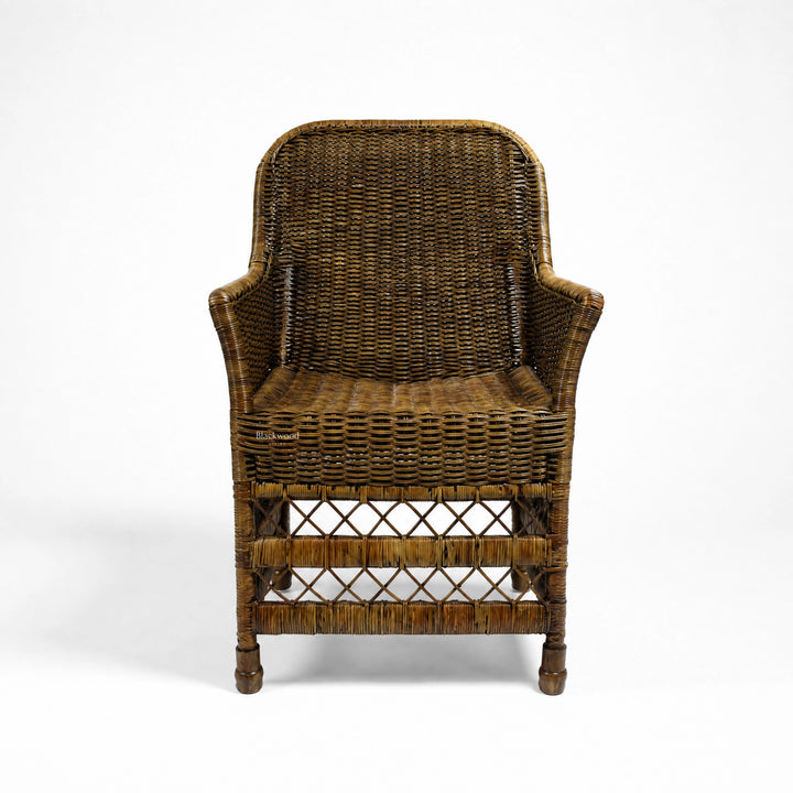 Malacca Accent Chair in woven natural rattan with curved arms and high back, warm plantation style.