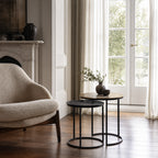 Verona Side Tables Set/2: two round tables with black metal frames and light wood tops in a bright living room.