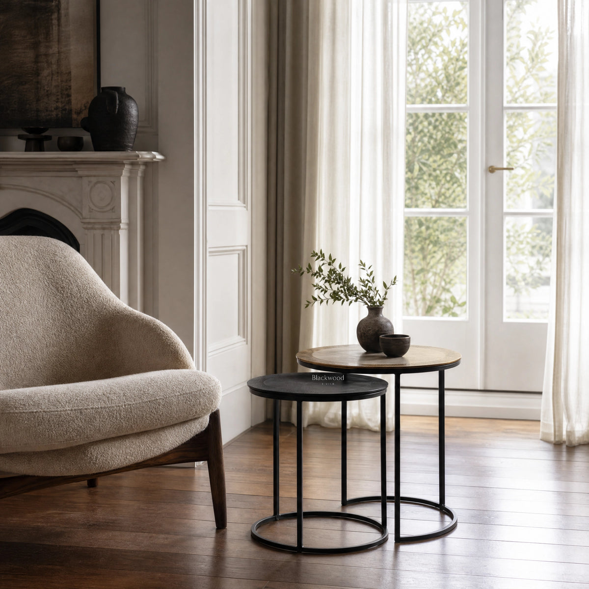 Verona Side Tables Set/2: two round tables with black metal frames and light wood tops in a bright living room.