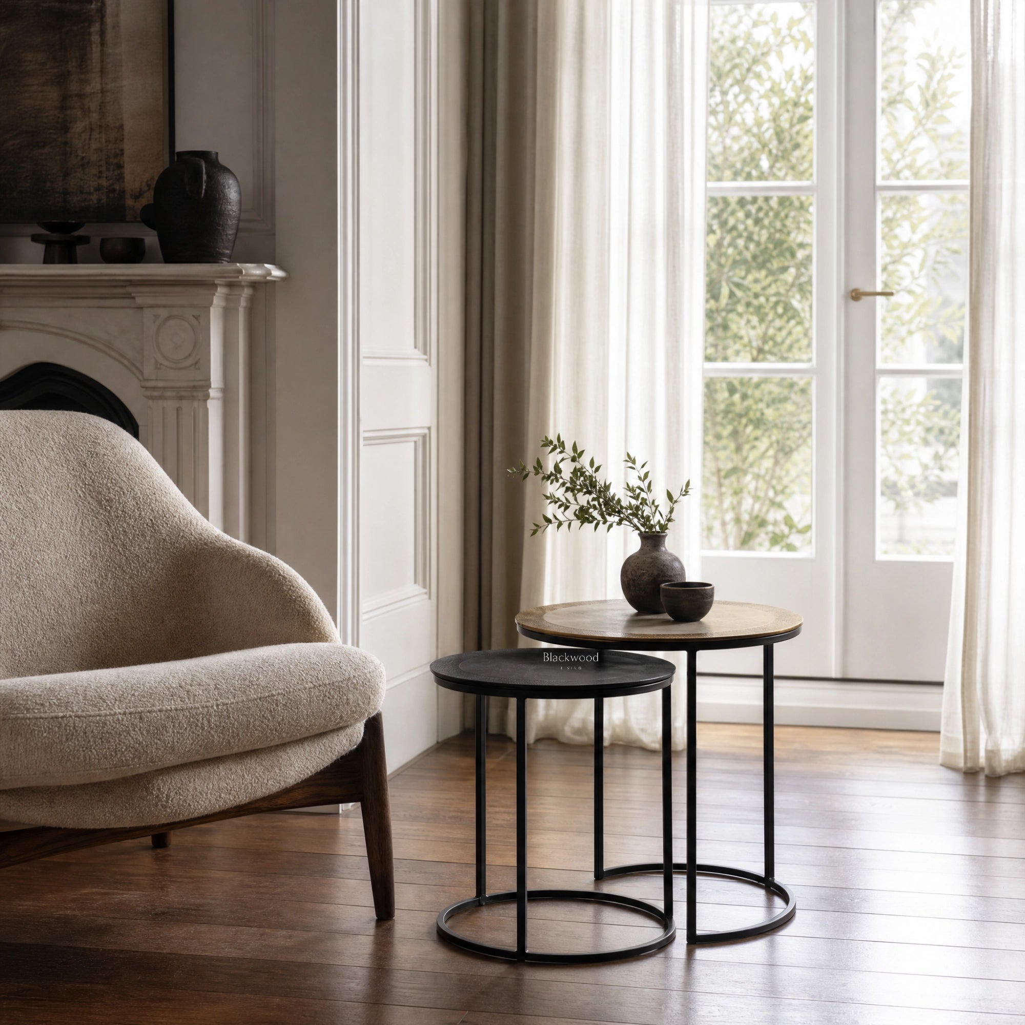 Verona Side Tables Set/2: two round tables with black metal frames and light wood tops in a bright living room.