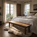 Renwick Bench Seat 170cm in solid mango wood with natural grain at the foot of a bed in a sunlit bedroom.
