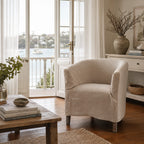 Stonehaven Accent Chair with linen slipcover, curved silhouette, and solid timber frame in a coastal living room.