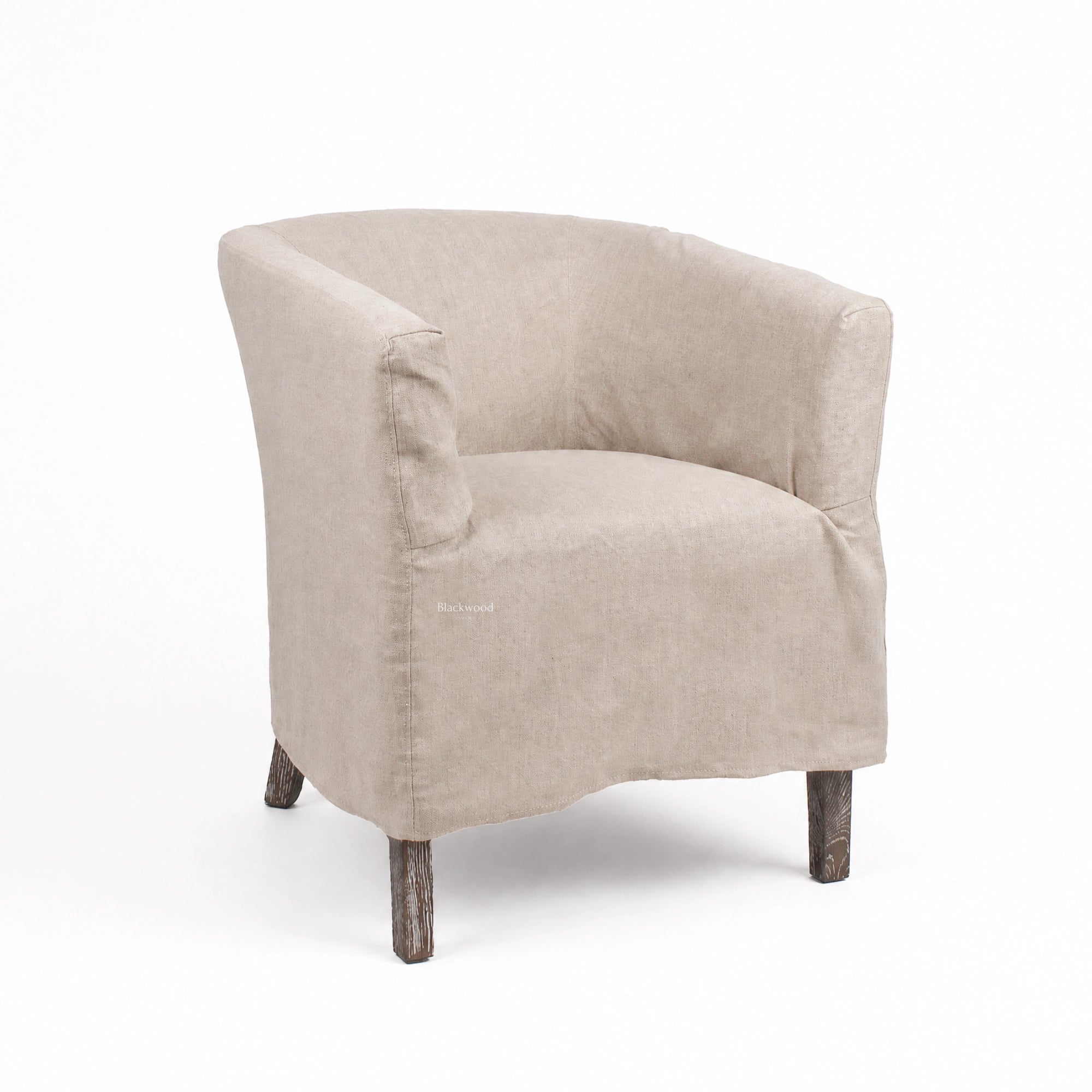 Stonehaven Accent Chair in beige linen slipcover with curved silhouette and solid timber legs.
