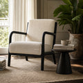 Java Occasional Chair - Black/Oat with cream herringbone fabric in a sunlit living room beside a plant and books.
