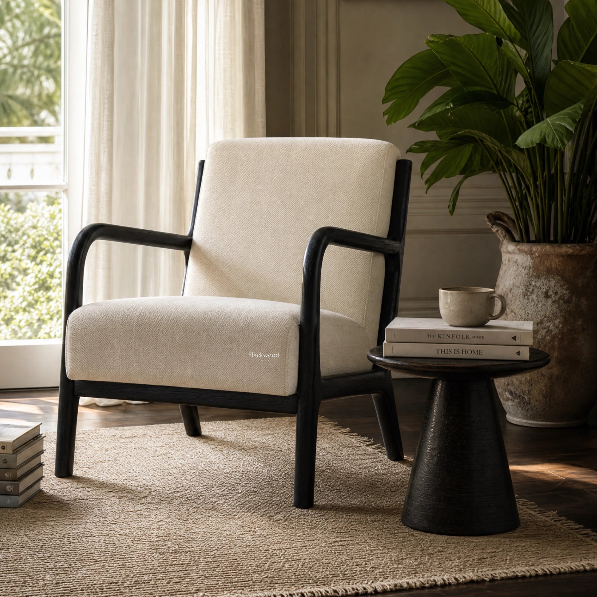 Java Occasional Chair - Black/Oat with cream herringbone fabric in a sunlit living room beside a plant and books.